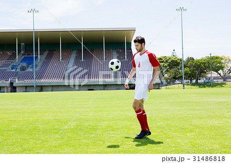 Football player juggling the football with his feet Football player juggling the football with his feet 31486818