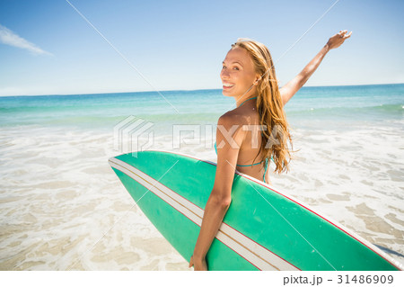 Woman posing with surfboard on beach 31486909