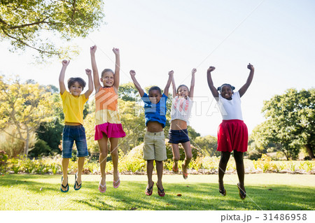 Happy kids jumping together during a sunny day Happy kids jumping together during a sunny day 31486958
