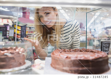 Portrait of woman looking at desserts shelf Portrait of woman looking at desserts shelf 31487285