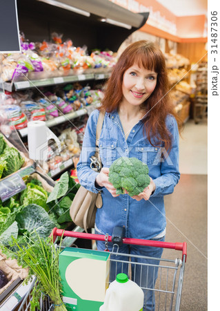 Smiling customer holding a broccoli Smiling customer holding a broccoli 31487306
