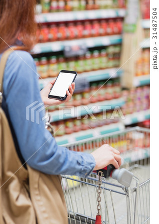 Customer in a store with a smartphone Customer in a store with a smartphone 31487504