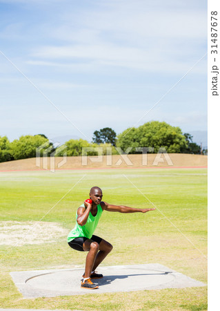 Male athlete preparing to throw shot put ball 31487678