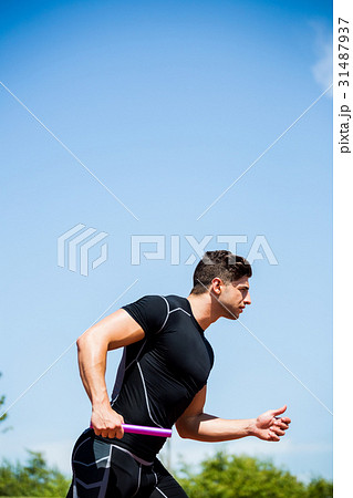 Relay athlete running with baton 31487937