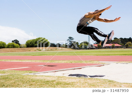 Athlete performing a long jump 31487950