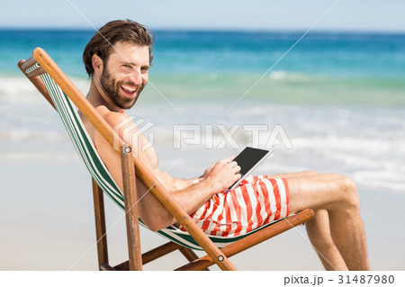 Man sitting on armchair at beach 31487980