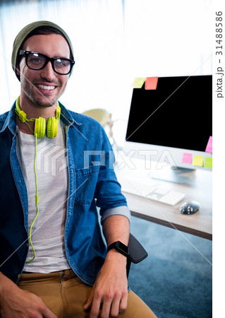 Smiling hipster businessman posing at desk 31488586