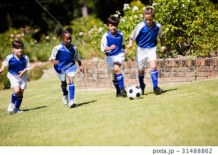Children wearing soccer uniform playing a match 31488862