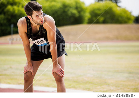 Tired athlete standing on running track 31488887