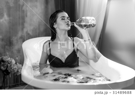 Sexy brunette woman drinking champagne while Sexy brunette woman drinking champagne while 31489688