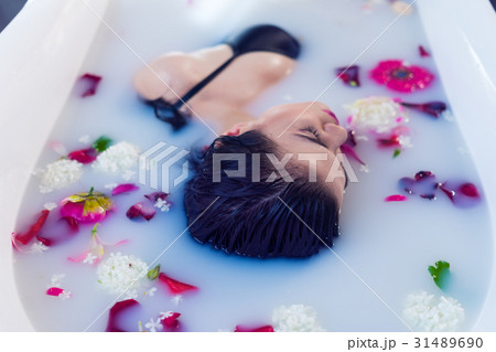 Sexy brunette woman relaxing in hot milk bath with Sexy brunette woman relaxing in hot milk bath with 31489690
