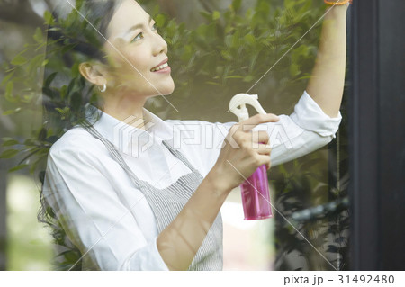 a young woman is doing housework of cleaning glass window. a young woman is doing housework of cleaning glass window. 31492480