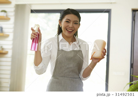 young lady is smiling and holding window cleaner and sponge young lady is smiling and holding window cleaner and sponge 31492501