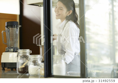 young asian lady is smiling and cooking in modern kitchen 31492559