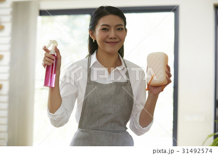 portrait of young woman holding sponge and glass cleaner 31492574