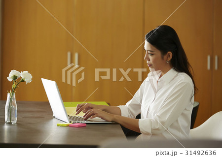 a woman is typing on the laptop. a woman is typing on the laptop. 31492636