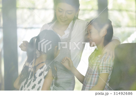 a picture of mom and two kids talking and smiling 31492686