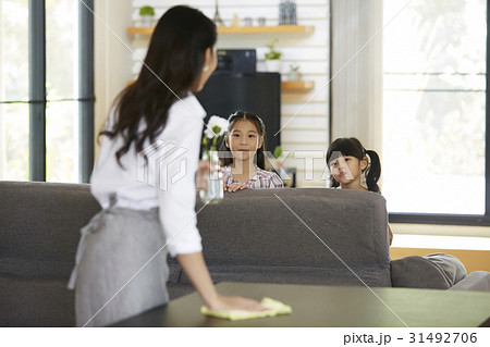 mom is cleaning table and talking to two kids at home. 31492706