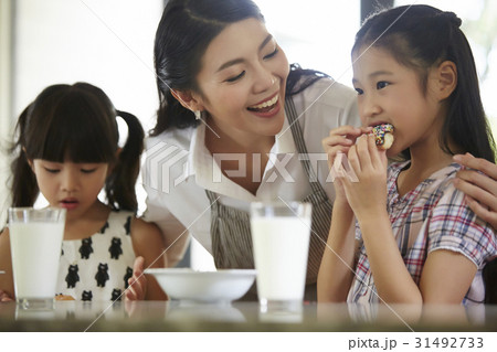 Mother is smiling at her daughters while having breakfast. 31492733