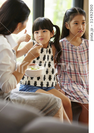 A little girl of two sister loves her mother's soup. 31492900