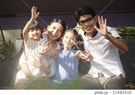 A happy Asian family is smiling, waving hands with you. 31492916