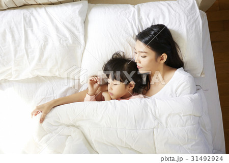 An Asian woman is hugging her daughter and sleeping together 31492924