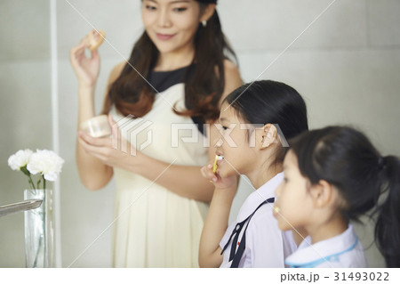 mother is making up, looking her kids brushing their teeth mother is making up, looking her kids brushing their teeth 31493022