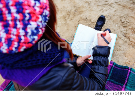 beautiful girl sitting on the beach  31497743