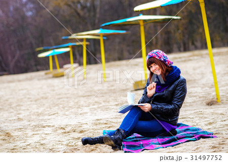 beautiful girl sitting on the beach  31497752