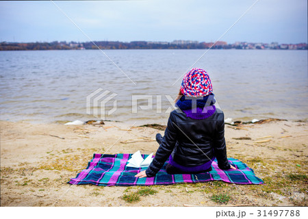 A woman on the beach starring at the restless Sea A woman on the beach starring at the restless Sea 31497788