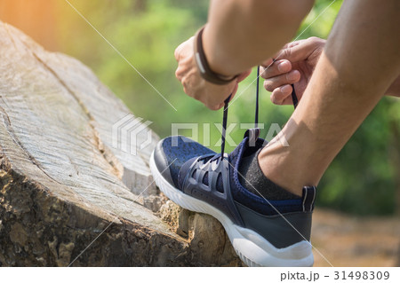 young man runner tightening running shoe laces, 31498309