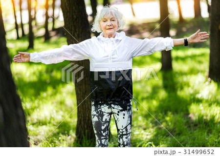 Happy old woman doing relaxation exercises in 31499652