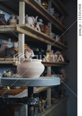 Clay pot in the foreground and shelves with potter Clay pot in the foreground and shelves with potter 31501408