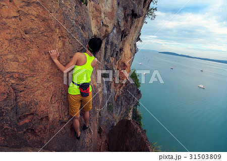 young woman rock climber climbing at seaside cliff young woman rock climber climbing at seaside cliff 31503809