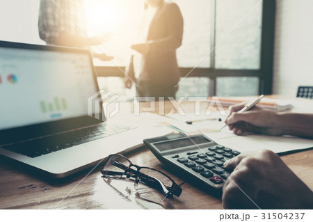Business team using a calculator and laptop Business team using a calculator and laptop 31504237