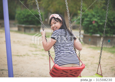 asian girl swinging on the playground asian girl swinging on the playground 31508230