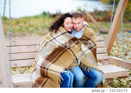 Amorous couple on romantic date on swings outdoor 31510175