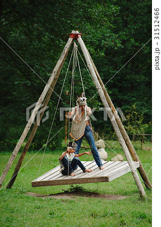 boys playing native american on swings boys playing native american on swings 31512466
