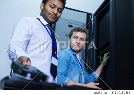 Nice positive engineers looking at the rack server 31513268