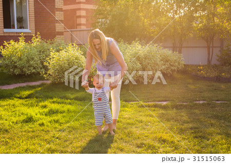 first steps of little boy in summer park 31515063