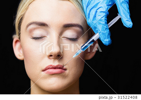 Woman receiving botox injection on her lips Woman receiving botox injection on her lips 31522408