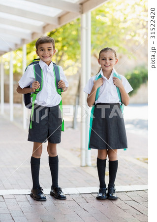 Smiling school kids standing in corridor 31522420