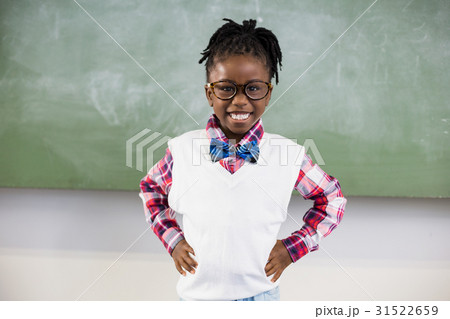 Portrait of happy schoolgirl standing with hand on hip 31522659