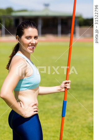 Portrait of female athlete standing with javelin Portrait of female athlete standing with javelin 31522796