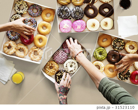 Hands selecting a variety of donut flavour Hands selecting a variety of donut flavour 31523110