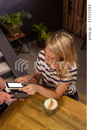 Woman paying with mobile payment Woman paying with mobile payment 31523383