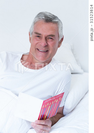 Senior man holding birthday greeting card Senior man holding birthday greeting card 31523614