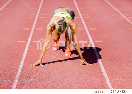 Female athlete ready to run on running track 31523800