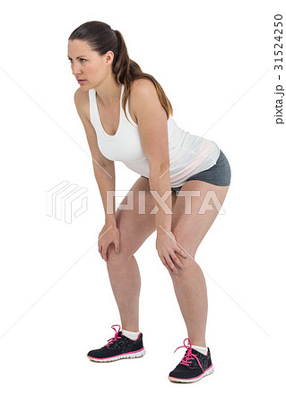 Tired athlete standing with hand on knee Tired athlete standing with hand on knee 31524250