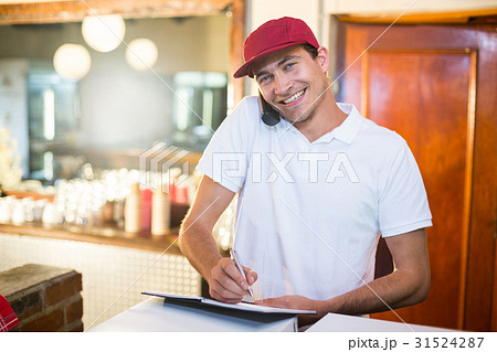 Pizza delivery man taking an order over the phone 31524287